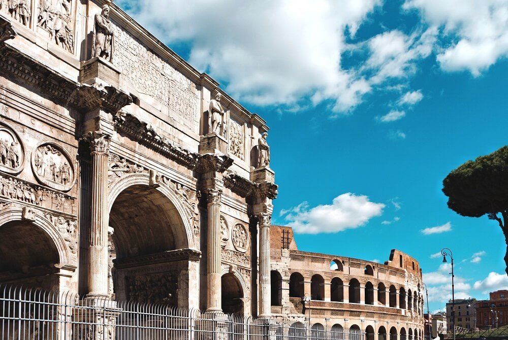 View of the Colosseum and Arch of Constantine in Rome, Italy, under a clear sky—ideal for promoting the Best Private Rome Tour: Sistine Chapel & Colosseum